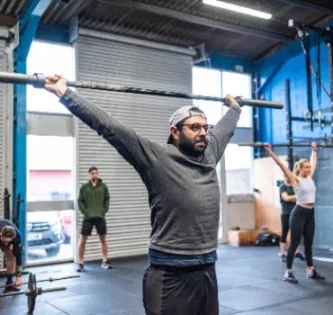 Man lifting barbell over head on training at CrossFit Tunbridge Wells